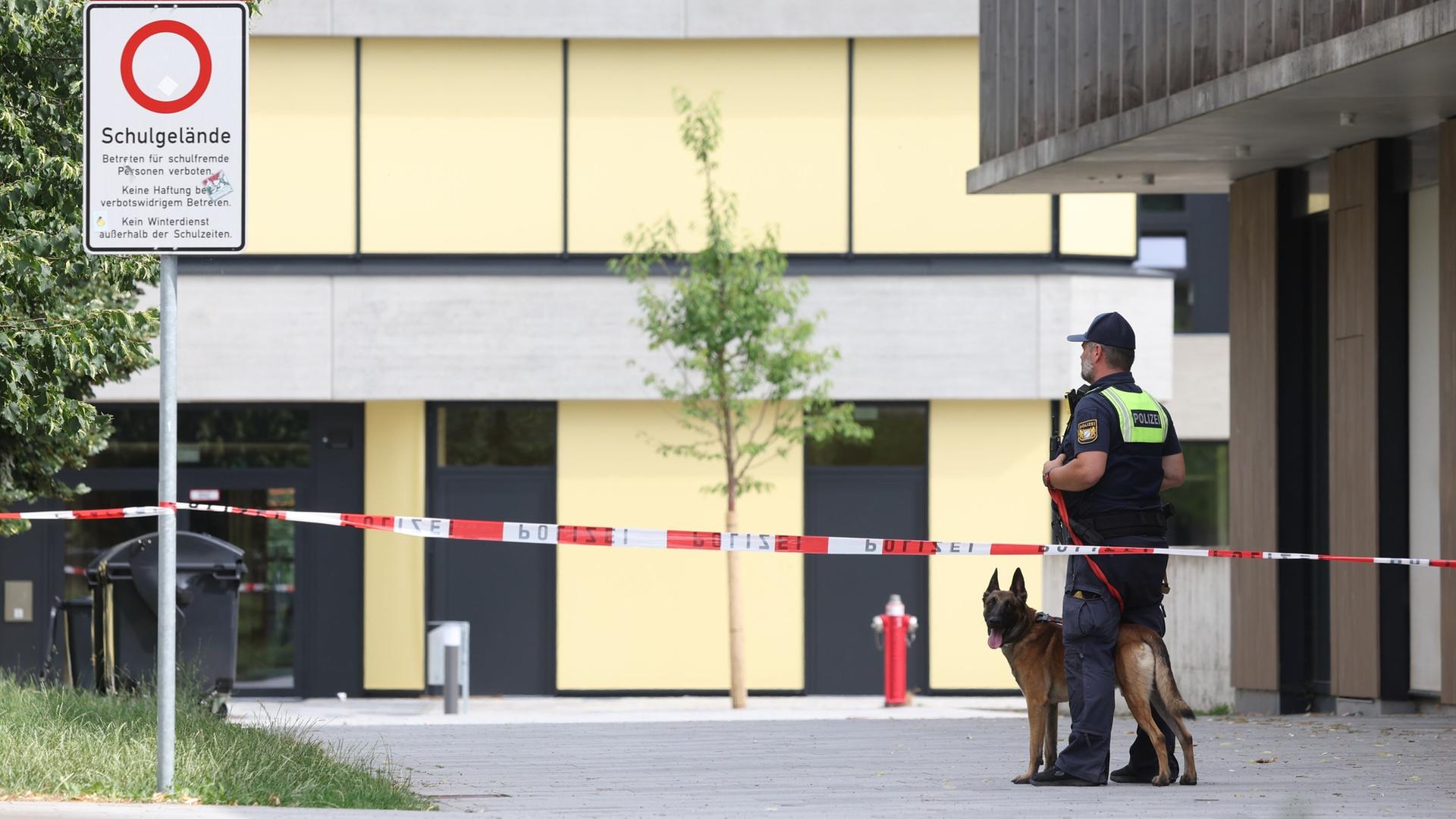 Ein Polizist mit Hund steht vor dem Welfen-Gymnasium, das GelÃ¤nde ist mit einem Flatterband abgesperrt. | picture alliance/dpa | Karl-Josef Hildenbrand